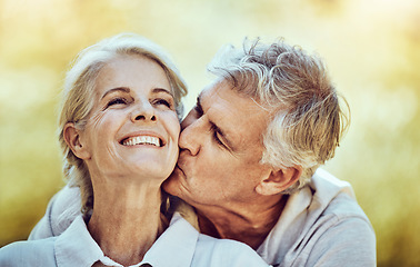 Image showing Senior couple, kiss and cheek with smile for love, romance and embrace together in the nature outdoors. Happy elderly woman and man kissing face for romantic bonding or quality time in happiness