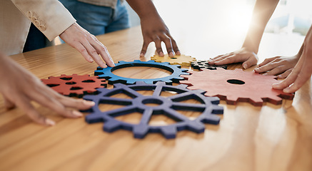 Image showing Hands, collaboration and gear with a business team working together in synergy for innovation at a workshop. Meeting, teamwork and creative with a man and woman employee group at work in the office