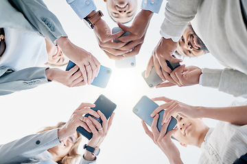 Image showing Phone in hands, technology and business people, collaboration and communication in team for company. Chat, internet and community diversity, networking and typing in teamwork circle from below