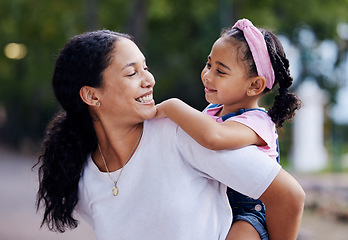 Image showing Woman, girl child and smile for piggyback ride in urban park, street and outdoor for love, bonding or care. Excited family, mother and daughter for riding back, comic laugh and relax on vacation walk