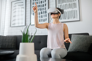 Image showing Virtual reality, metaverse and gaming with a woman in the living room of her home using a headset to access a 3d game. Futuristic, vr and technology with a female gamer using ai to play online games