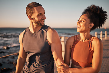 Image showing Black couple, fitness and walking at the beach with smile for conversation, talk or sunset together in the outdoors. Happy man and woman enjoying fun walk smiling for holiday break by the ocean coast