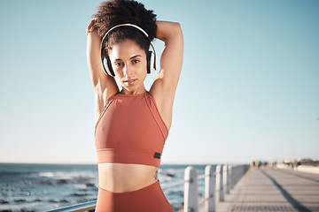 Image showing Beach, stretching and portrait of a woman athlete doing exercise before running or training for a race or marathon. Fitness, sports and female runner doing arm warm up before cardio workout by ocean.