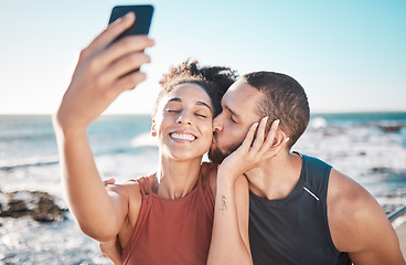 Image showing Selfie kiss, gratitude and couple with a phone for streaming, training and love at the beach in Bali. Caring, exercise and affectionate man and woman with a smile for a mobile photo after a workout