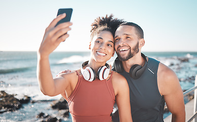 Image showing Fitness, couple and phone for selfie at the beach with smile for running, exercise or workout together. Happy woman and man smiling in happiness looking at smartphone for photo after run by the ocean