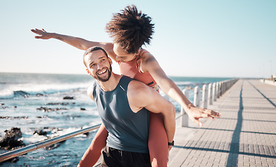 Image showing Summer, freedom and couple piggyback by ocean enjoying holiday, vacation and quality time on weekend. Love, dating and black man and woman relax after running, fitness workout and training by beach