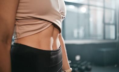 Image showing Fitness, stomach and woman in a gym for exercise, health or wellness for weightloss training. Sports, tummy tuck and closeup of a slim female athlete or model abs after a workout in a sport center.