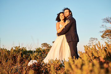 Image showing Bride, groom and wedding in nature at sunset by interracial couple, happy and excited for love, romance and relationship. Marriage, woman and man embracing at outdoor ceremony, in love and sweet joy