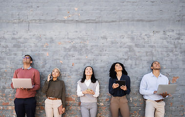 Image showing Diversity, technology and team standing at wall looking up and working at tech development company waiting for hr. Human resources, job opportunity and group of people with laptop, phone and tablet.