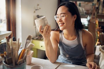 Image showing Artist, Asian and woman as small business entrepreneur happy about design and product at a workshop. Pottery, mug and clay sculpture by creative startup female smiling and satisfied by art