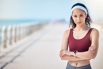 Image showing Fitness, portrait and woman with arms crossed at beach promenade for exercise, wellness and mockup in Miami. Female sports athlete standing at seaside outdoor for workout, summer training and running