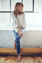 Image showing Woman, thinking and posing against a window, relax and smile, cheerful and content in her home. Girl, contemplating and enjoying free time on the weekend, laughing and having fun standing alone