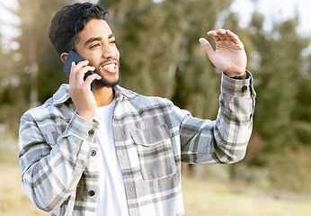 Image showing Phone call, man and relax while in a park for walking, calm and smile against a tree background. Smartphone, conversation and handsome male enjoying a walk in nature while talking, looking and fun