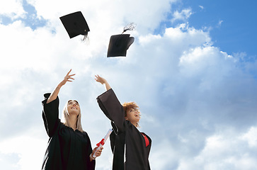 Image showing Graduate women, friends and cap in air for celebration, happiness or success for studying together at campus. University student, black woman and diversity for goal, vision and achievement at college