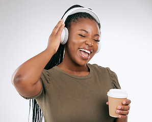 Image showing Headphones, black woman and music listening with coffee of a happy young person in a studio. White background, isolated and happiness of a excited female hearing audio and singing to song alone