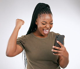 Image showing Black woman, phone and victory for winning, discount or sale against a grey studio background. Happy African American female winner excited for achievement, good news or celebrating win on smartphone