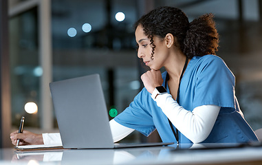 Image showing Doctor, laptop and writing notes at night thinking about healthcare solution, idea or planning at hospital. Woman medical nurse working late in focus with notebook and computer for research at clinic