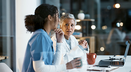 Image showing Doctor, team and laptop in discussion at night for healthcare strategy or planning at hospital. Women medical professional in collaboration working late together for teamwork, conversation or ideas