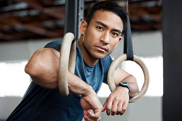 Image showing Portrait, gymnastic rings and olympics with a man gymnast hanging on equipment for workout in gym. Face, fitness and exercise with a male athlete training in gymnastics for health or power