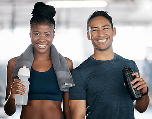 Image showing Portrait, fitness and drinking water with a sports couple in the gym together after a workout. Diversity, smile and towel with a happy young man and woman in a health center for exercise or training