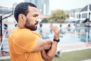 Image showing Exercise, black man and stretching outdoor, focus and workout for wellness, endurance or healthy lifestyle. African American male, runner or athlete stretch arms warm up or start training for fitness