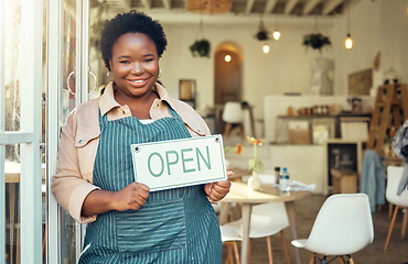 Image showing Open sign, portrait and black woman business startup in cafe, restaurant or retail store with smile for success. Boss, manager or person hand holding board for welcome service at new coffee shop