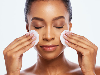 Image showing Beauty, skincare and cotton on face of woman in studio for dermatology, cosmetics and natural skin. Aesthetic model person with cleaning makeup for healthy facial glow isolated on a white background