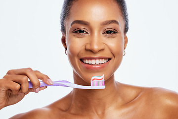 Image showing Portrait, cleaning and a black woman brushing teeth in studio isolated on a white background for oral hygiene. Face, toothbrush or toothpaste with a young female posing for dental care on blank space