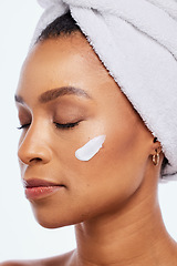 Image showing Black woman, skin care and beauty cream in studio for dermatology, cosmetics and natural glow. Aesthetic model person with luxury spa facial and healthy face with towel isolated on a white background