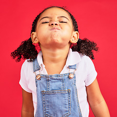 Image showing Attitude, childhood and face of girl on red background in studio with angry, upset and frustrated reaction. Emoji, comic and young kid with air in cheeks, tantrum behaviour and mad facial expression