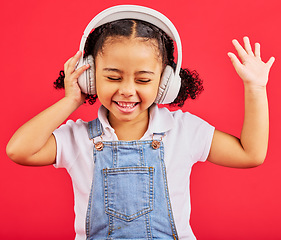 Image showing Dancing, child and headphones for music, fun radio and girls podcast on isolated red background and studio. Smile, happy and energy kid listening to dance audio, sound and streaming media on backdrop