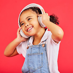 Image showing Dancing, kid and headphones for music, fun radio and girls podcast on isolated red background and studio. Smile, happy and energy child listening to dance audio, sound and streaming media on backdrop