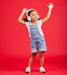 Image showing Dance, energy or happy kid on music headphones, fun radio or dancing podcast with hands up on red background. Smile, girl or dancer child listening to audio, streaming sound or media on studio mockup