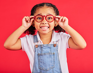 Image showing Excited child, portrait or fashion glasses on red background in children trend, eyes care or wellness health. Smile, happy or little girl with optometry frames for vision support or medical insurance