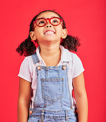 Image showing Looking up, child and fashion glasses on red background in kids style, eyes care and wellness health insurance. Smile, happy and little girl with optometry frames, vision support or retail sales deal