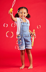 Image showing Child, portrait or bubbles playing on isolated red background in hand eye coordination, kids activity or fun game. Smile, happy or little girl and soap wand, studio toy or breathing development skill