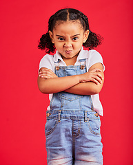 Image showing Child, arms crossed or angry portrait on isolated red background for tantrum face, behavior problem or stubborn. Mad, annoyed or frustrated little girl with sulking, grumpy or anger facial expression