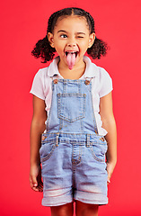 Image showing Child, face and tongue out on isolated red background in goofy, silly games and playful facial expression. Happy, kid and funny little girl with comic, emoji and winking charades in studio activity