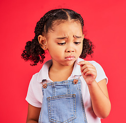 Image showing Child, sad and finger injury with plaster on isolated red background for cut, sore and insect bite. Upset, unhappy and hurt little girl with bandage for medical help, healthcare wellness or first aid