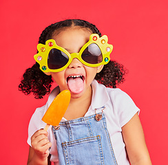 Image showing Child, sunglasses or ice cream on isolated red background or tongue, cool or summer fashion clothes. Happy, kid or girl with lolly, cold sweet or funny glasses for sun protection during fun vacation