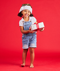 Image showing Portrait, christmas and gift with a black girl on a red background in studio for festive celebration. Box, present and kids with a happy female child celebrating a holiday tradition in december