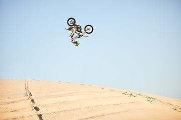 Image showing Motorcycle, jump and sports athlete in desert, dirt bike rally outdoor with extreme sport stunt, power and action. Nature, adventure and freedom, fitness challenge and biker person, mockup and travel