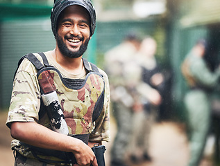 Image showing Happy, portrait or man with paintball gun in games arena, team competition or sports challenge in military uniform. Smile, soldier or army person with shooting paint equipment in fun warfare training