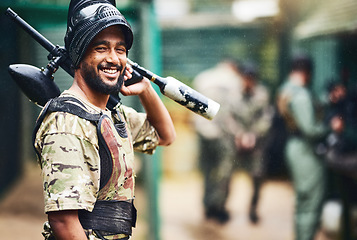 Image showing Smile, portrait or man and paintball gun in games arena, teamwork leadership or sports challenge in military uniform. Happy, shooter or playing rifle for soldier, army person or fun warfare training