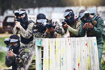 Image showing Paintball, gun or team play in a shooting game together on a fun battlefield on holiday. Men on a mission, fitness or players aim with military weapons gear for survival in an outdoor competition