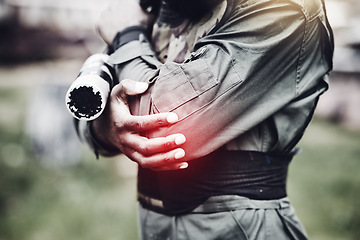 Image showing Paintball, pain or man with an elbow injury after playing a shooting game on a fun battlefield on holiday. Red glow, fitness or hands of player in an arm accident in an outdoor military competition