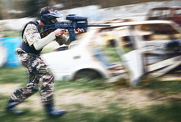 Image showing Paintball, aim and man with a gun for a game with blur motion at an outdoor arena or field. Challenge, competition and male soldier with a camouflage military outfit shooting a rifle on a battlefield