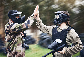 Image showing Paintball, team and high five for winning victory, achievement or successful game time on the field. Man and woman in celebration for war win in extreme sports together and touching hands in teamwork