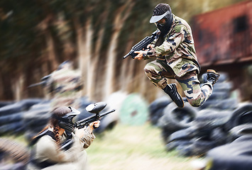 Image showing Paintball, gun or people play in a shooting game with fast action on a fun battlefield on holiday. Man on mission, fitness or player jumping with weapons gear for survival in an outdoor competition