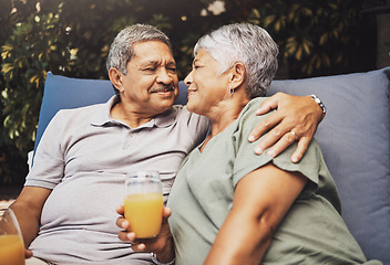 Image showing Senior couple, hug and juice on a garden patio sofa with love and care for marriage and retirement. Conversation, morning talking and relax discussion of elderly man and woman outdoor with happiness